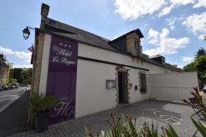 a white building with a purple door on a street at Hôtel Le Bayeux in Bayeux