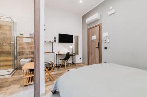 een slaapkamer met een bed, een bureau en een tv bij Panurban Rooms by Wonderful Italy in Palermo