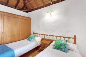 Un dormitorio con dos camas y un armario de madera. en Casa Serradero, en Tijarafe 16 fotos más