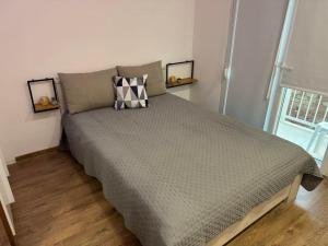a bed in a bedroom with two pictures on the wall at Lyda Apartment in Alexandroupoli