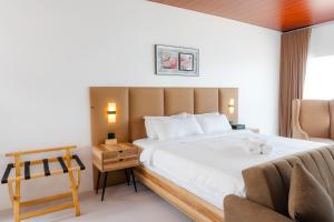 een hotelkamer met een bed en een stoel bij Q Beach Resort in Cabangan