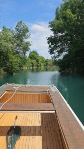 a boat on a river with a wooden deck at Villa Longina in Ljubuški