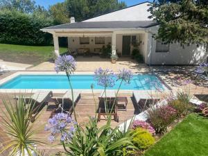 a backyard with a swimming pool and a house at Chalet familiar con piscina in Valdemorillo