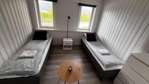 una camera con due letti e un tavolo e due finestre di Storfossen Hostel a Gratangen