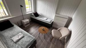 een kleine woonkamer met een bank en een stoel bij Storfossen Hostel in Gratangen