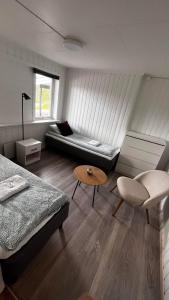 GratangenにあるStorfossen Hostelのベッド2台、ソファ、テーブルが備わる客室です。