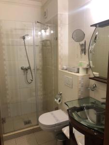 a bathroom with a shower and a toilet and a sink at Villa Hotel in Debrecen