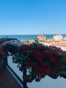 a bunch of red and white flowers on a balcony at A Casa Così B&b in Marzocca di Senigallia