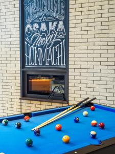 a pool table with balls on it next to a fireplace at MOXY Osaka Honmachi in Osaka