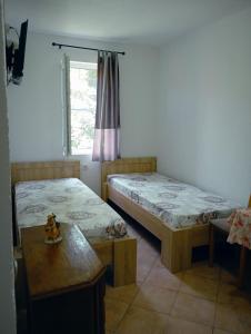 a room with two beds and a table and a window at Vila Teodora in Star Dojran +60 photos