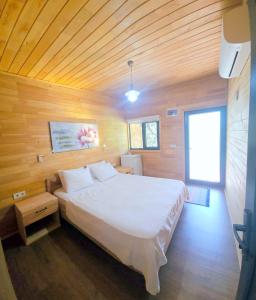 um quarto com uma cama branca num quarto de madeira em Baraka House em Cıralı