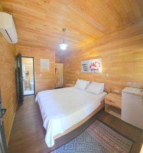 um quarto com uma cama branca num quarto de madeira em Baraka House em Cıralı
