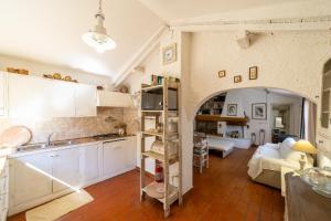 uma cozinha e sala de estar com um arco em Cottage Pura Vigna immerso nella natura vicino al mare em Porto Santo Stefano
