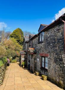 an old stone house with a cobblestone street at Miller's Cottage in Woolfardisworthy