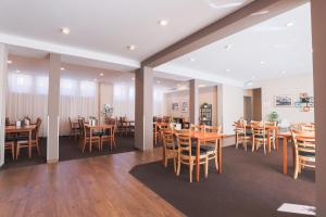 Hotel Bruy في شتوتغارت: غرفة طعام مع طاولات وكراسي خشبية