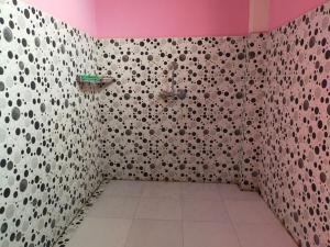 a bathroom with a shower with a pink wall at itynnad homestay in Shillong