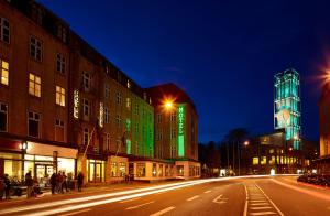 une rue de la ville avec des bâtiments la nuit et des lumières vertes dans l'établissement Scandic The Mayor, à Aarhus