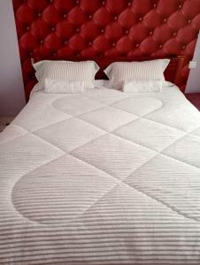 a bedroom with a large bed with a red headboard at The Glamour House in Juja