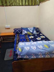 a bed with a blue comforter and pillows at Private home in Gangtok