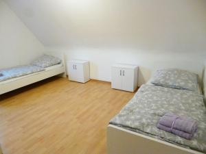 - 2 lits dans une petite chambre dotée de parquet dans l'établissement Nice Apartment in Vöhringen, à Vöhringen
