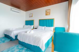 two beds in a room with blue and white at Q Beach Resort in Cabangan