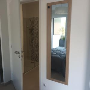 a room with a bedroom with a shower and a mirror at Cosy Diem Cap d'Agde in Cap d'Agde