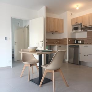 a kitchen with a table and chairs in a room at Cosy Diem Cap d'Agde in Cap d'Agde