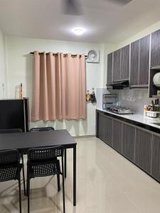 een keuken met een tafel en stoelen in een kamer bij Igo Homestay Subang Airport - Standard room in Shah Alam