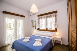 Un dormitorio con una cama azul con toallas. en Boskos Villa 2, en Nea Vrasna