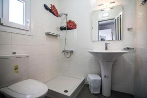 Un baño blanco con inodoro y lavabo. en Boskos Villa 2, en Nea Vrasna 24 fotos más