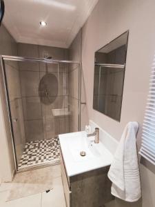 a bathroom with a shower and a sink at Palmera Guest House in Krugersdorp +34 photos