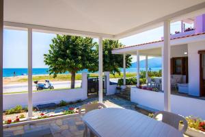 Una casa con mesa y vista a la playa. en Boskos Villa 2, en Nea Vrasna