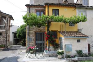 a yellow house with a table and chairs in front of it at La Dimora del Passato B&B in Castellone