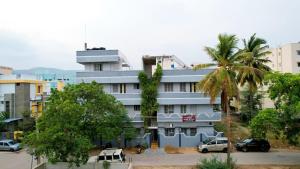 a building with a palm tree in front of it at ABS Home Stay, 2Bed room AC Flats,Tirupati in Tirupati