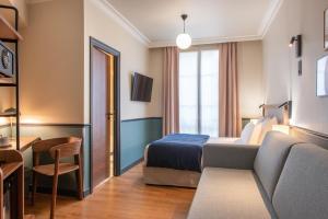 une chambre d'hôtel avec un lit et un canapé dans l'établissement Hotel Terminus Lyon, à Paris