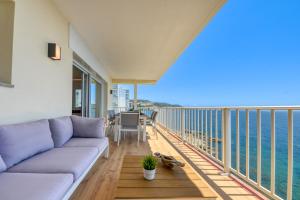 a living room with a couch and a balcony with the ocean at Ático Crucero Suite VIP in Roses