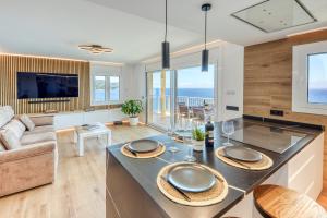 a kitchen and living room with a view of the ocean at Ático Crucero Suite VIP in Roses
