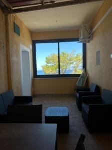 a waiting room with couches and a large window at MareaSol Casa Vacanze in Santa Maria di Castellabate