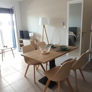 a dining table and chairs in a living room at Cosy Diem Cap d'Agde in Cap d'Agde