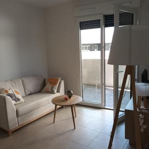 a living room with a couch and a table at Cosy Diem Cap d'Agde in Cap d'Agde