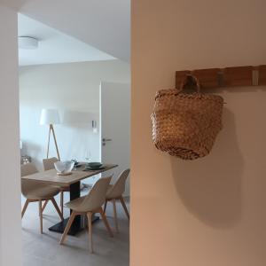 a dining room with a table and chairs and a basket on the wall at Cosy Diem Cap d'Agde in Cap d'Agde