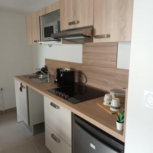 a kitchen with a sink and a stove top oven at Cosy Diem Cap d'Agde in Cap d'Agde