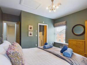 a bedroom with a large bed with blue pillows at Seaside Cottage, Moments from Ryde's Golden Sands, Sleeps 4 in Ryde