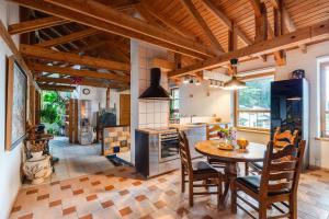 kuchnia z drewnianymi sufitami oraz stołem i krzesłami w obiekcie House of Sun w Wilnie