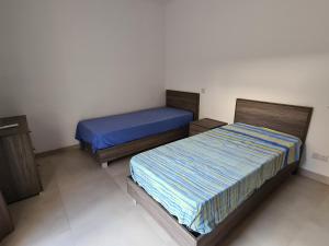 two beds in a small room withermottermottermott at Cescaren Gozo Ghajnsielem in Għajnsielem +2 photos