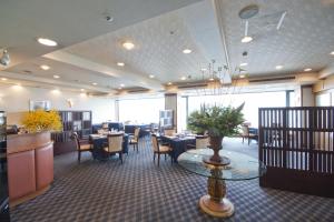 a dining room with tables and chairs in a restaurant at Shimonoseki Grand Hotel in Shimonoseki