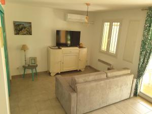 a living room with a couch and a flat screen tv at L'Oliveraie in Hyères
