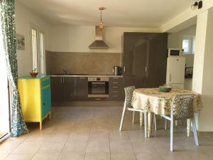 a kitchen with a table and chairs and a refrigerator at L'Oliveraie in Hyères