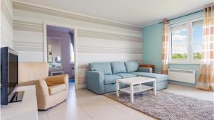 a living room with a blue couch and a table at Niska, Sun & Snow in Krynica Morska
