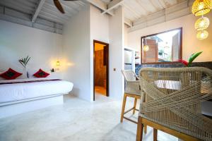 una camera da letto con un letto, un tavolo e delle sedie di Alchemy Studio Ubud ad Ubud Altre 14 foto